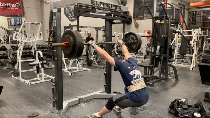 @austin90kg squatting in a Conquering Barbell tee