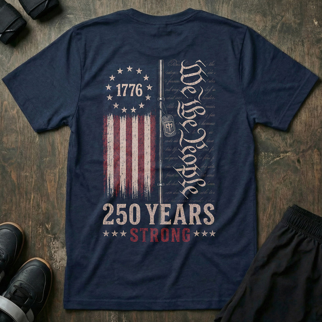 250 Years Strong tee in Navy: a distressed 1776 flag split alongside a barbell with a CB dog tag hanging from it