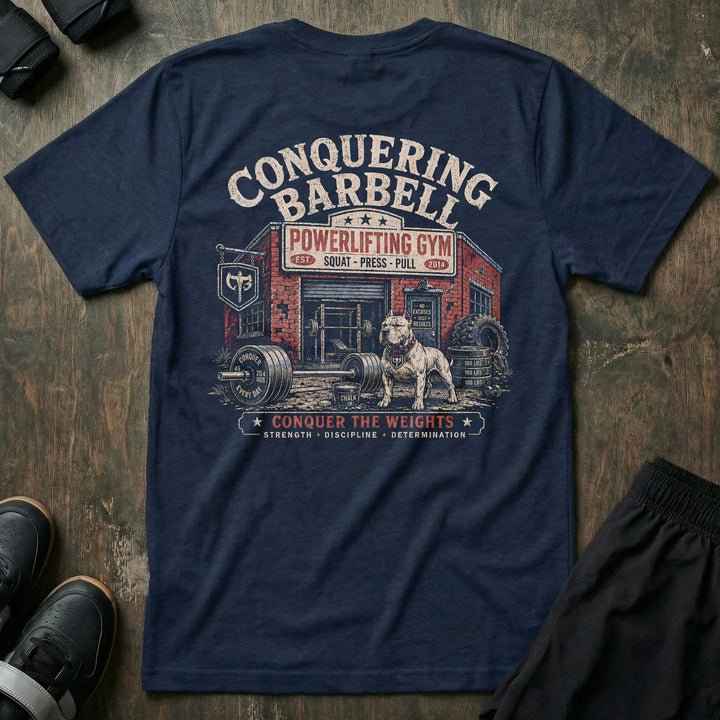 Powerlifting Gym tee in Navy: a full-color vintage gym scene with a brick CONQUERING BARBELL POWERLIFTING GYM storefront