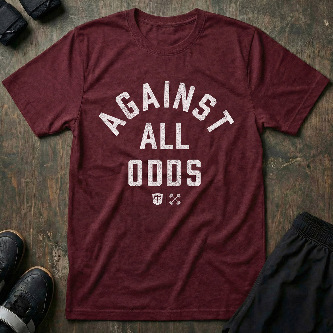 Against All Odds tee in Maroon: AGAINST ALL ODDS in bold distressed collegiate lettering across the front