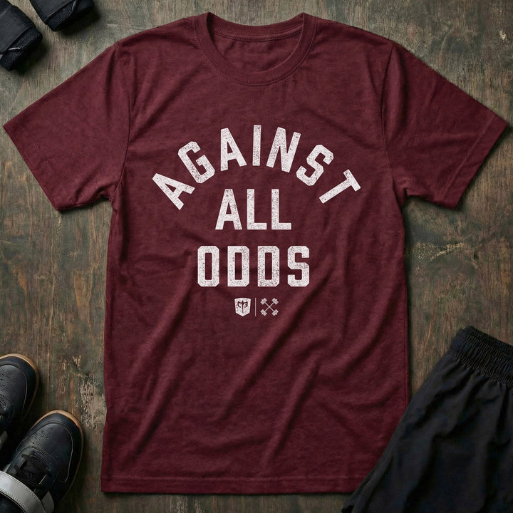 Against All Odds tee in Maroon: AGAINST ALL ODDS in bold distressed collegiate lettering across the front