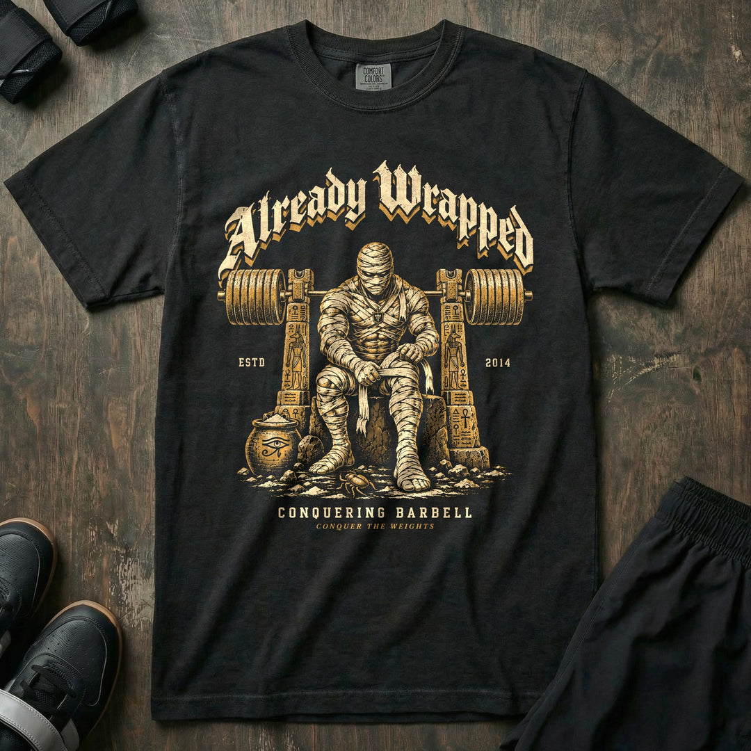 Already Wrapped - Relaxed Fit Tee front graphic in Black with a mummy wrapping up under a loaded barbell - Conquering Barbell