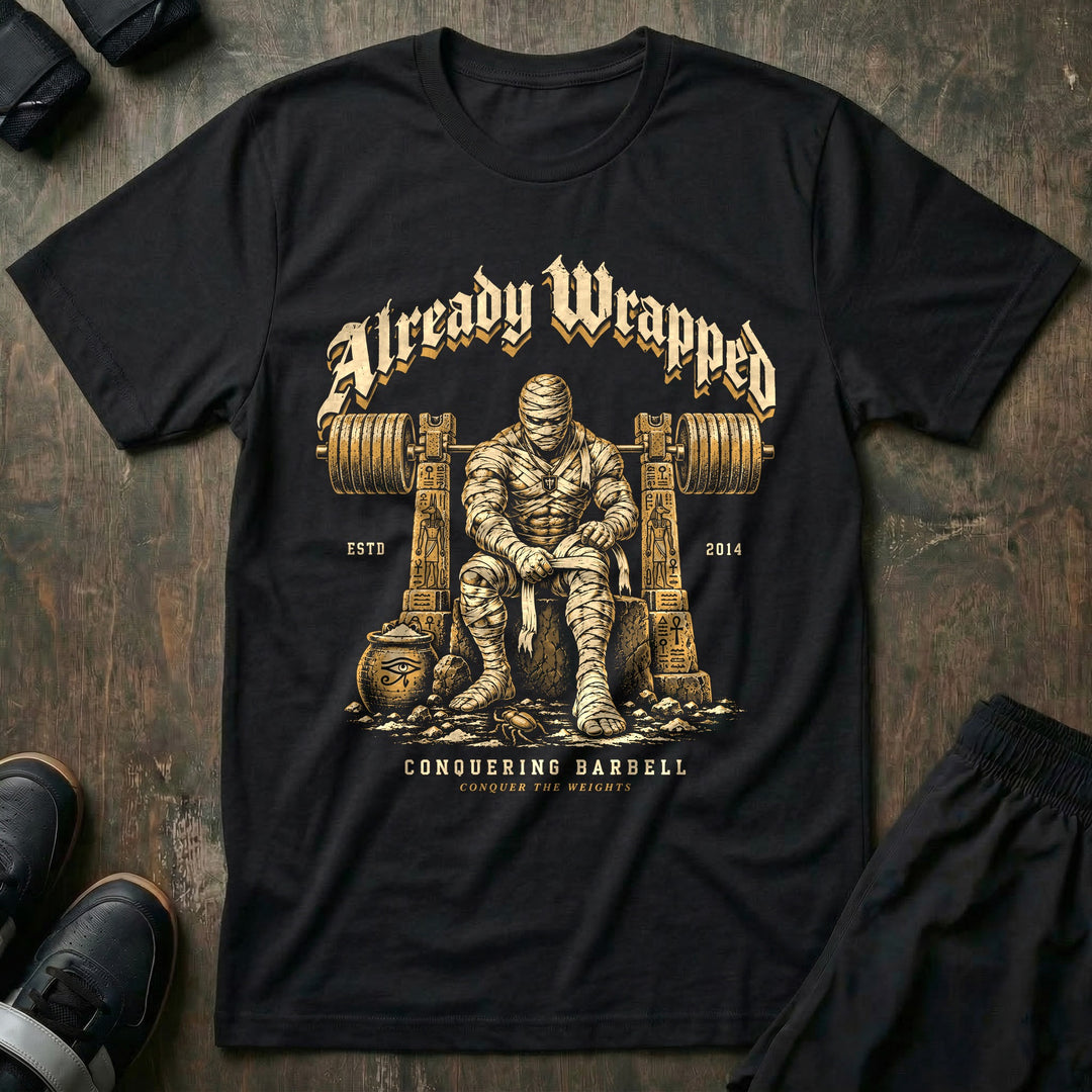 Already Wrapped - Tee front graphic in Black with a mummy wrapping up under a loaded barbell - Conquering Barbell