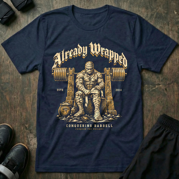 Already Wrapped - Tee front graphic in Navy with a mummy wrapping up under a loaded barbell - Conquering Barbell