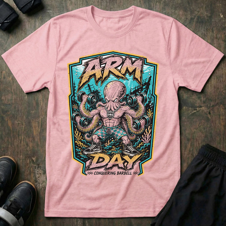 Arm Day Octopus tee in Pink: a jacked octopus in board shorts and skate shoes curling multiple dumbbells at once