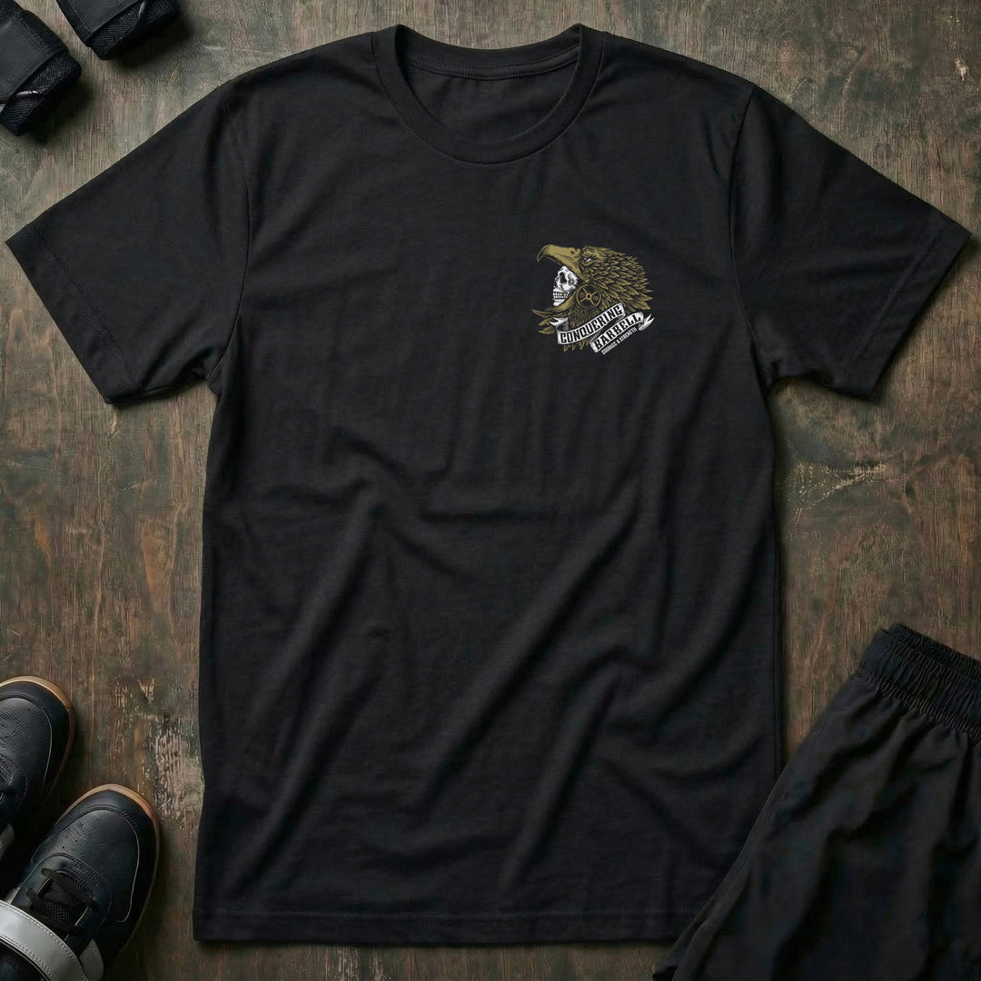 Aztec Eagle Warrior tee in Black: a skull warrior in a gold-feathered eagle headdress with a CONQUERING BARBELL ribbon banner