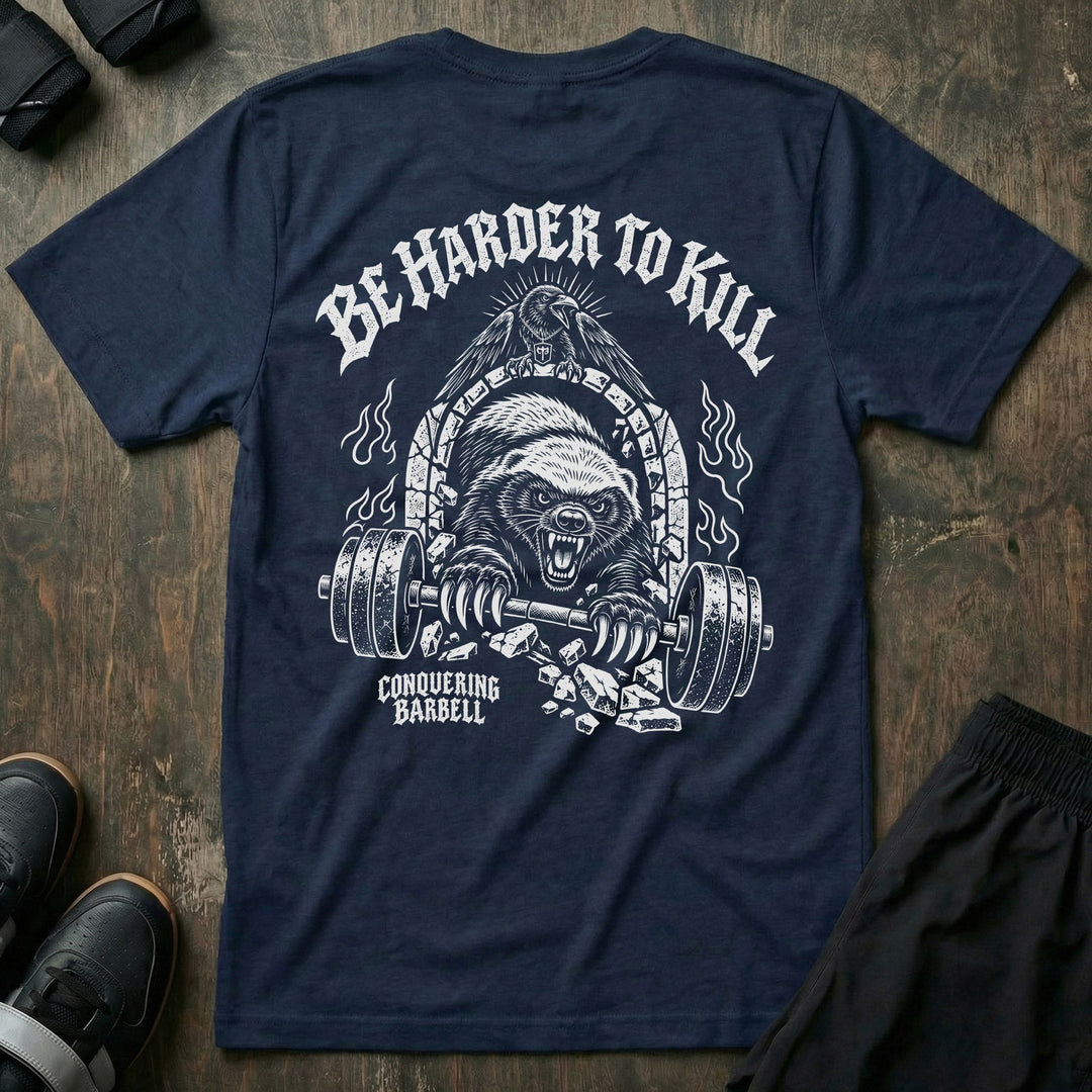 Be Harder to Kill Honey Badger tee in Navy: a snarling honey badger bursting through a stone arch with a loaded barbell