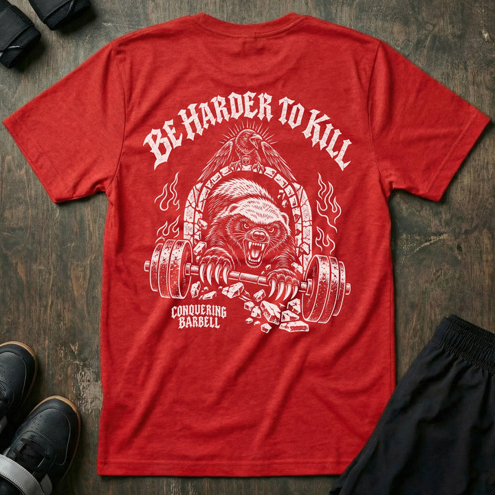 Be Harder to Kill Honey Badger tee in Red: a snarling honey badger bursting through a stone arch with a loaded barbell