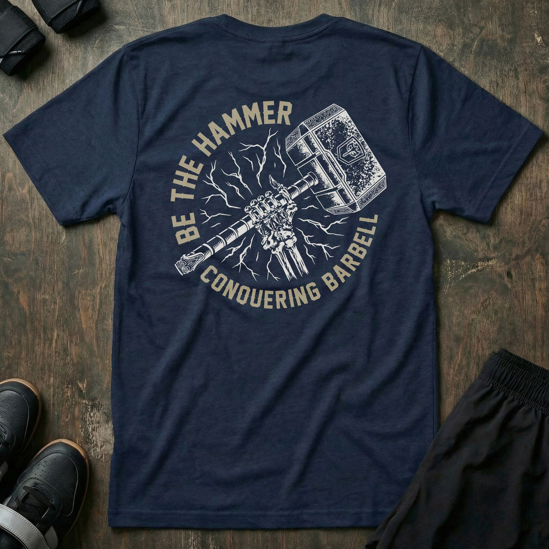 Be the Hammer tee in Navy: a skeletal fist gripping an ornate war hammer surrounded by lightning strikes and crackling energy