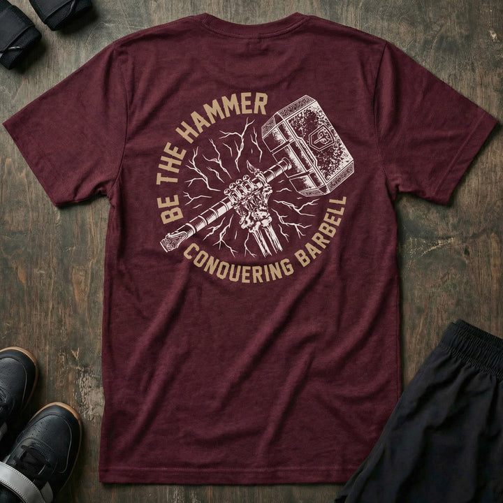 Be the Hammer tee in Maroon: a skeletal fist gripping an ornate war hammer surrounded by lightning strikes