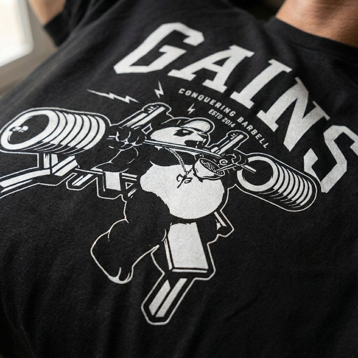 Bench Press Panda tee in Black: a panda locked under a loaded barbell mid-press