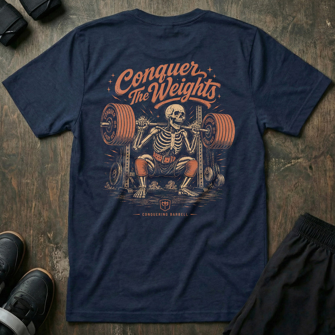 Bone Deep tee in Navy: a grinning skeleton in a lifting belt squatting a fully loaded barbell in the power rack