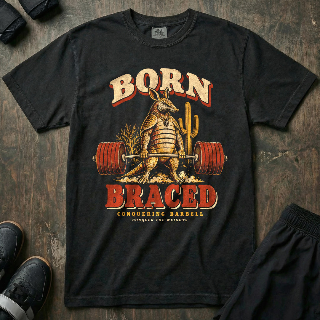 Born Braced - Relaxed Fit Tee front graphic in Black with an armadillo deadlifting a loaded barbell in the desert - Conquering Barbell