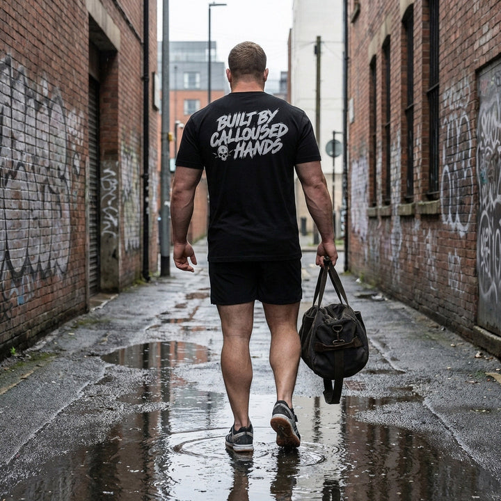 Built by Calloused Hands tee in Black: BUILT BY CALLOUSED HANDS in raw white brush lettering with a small skull