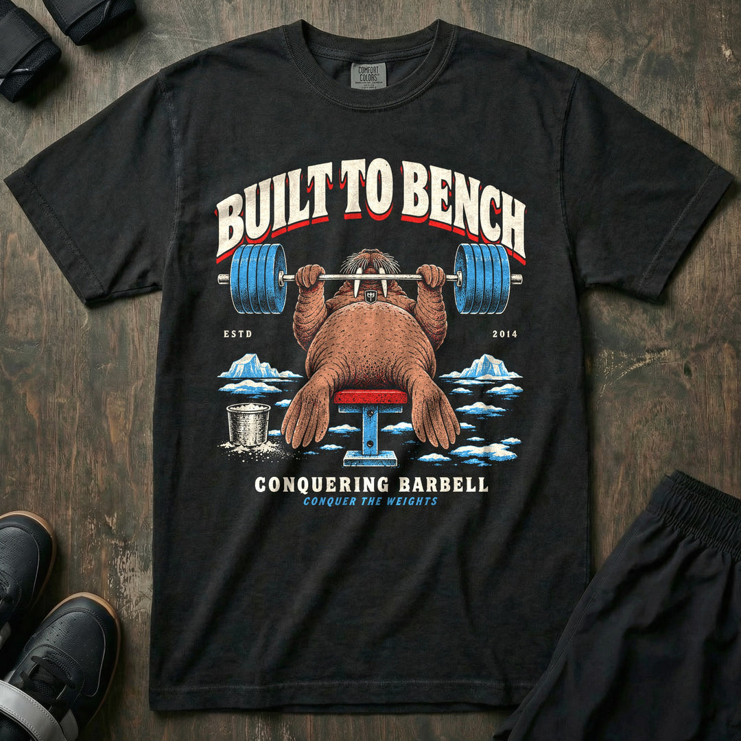 Built to Bench - Relaxed Fit Tee front graphic in Black with a walrus bench pressing a loaded barbell on the ice - Conquering Barbell