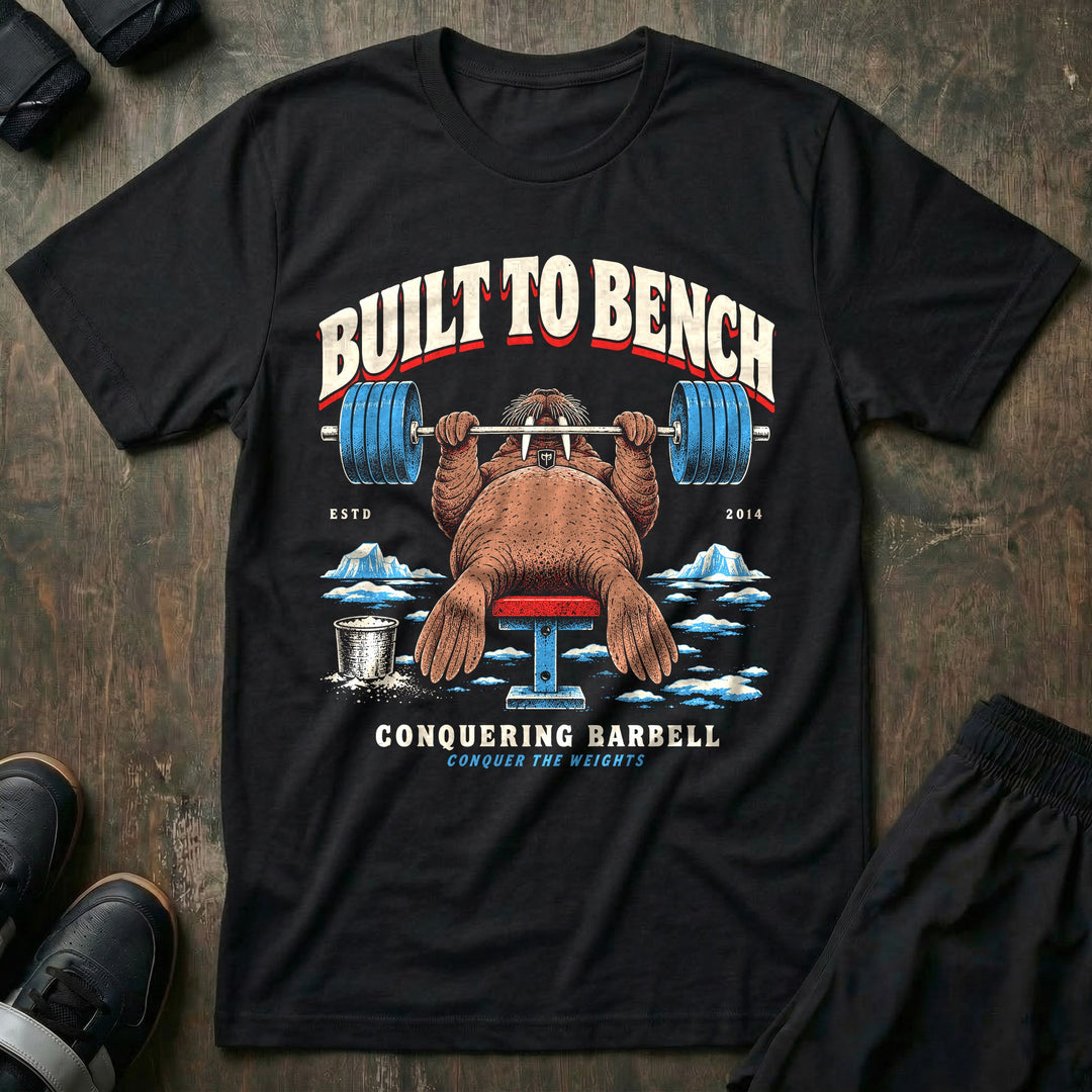 Built to Bench - Tee front graphic in Black with a walrus bench pressing a loaded barbell on the ice - Conquering Barbell