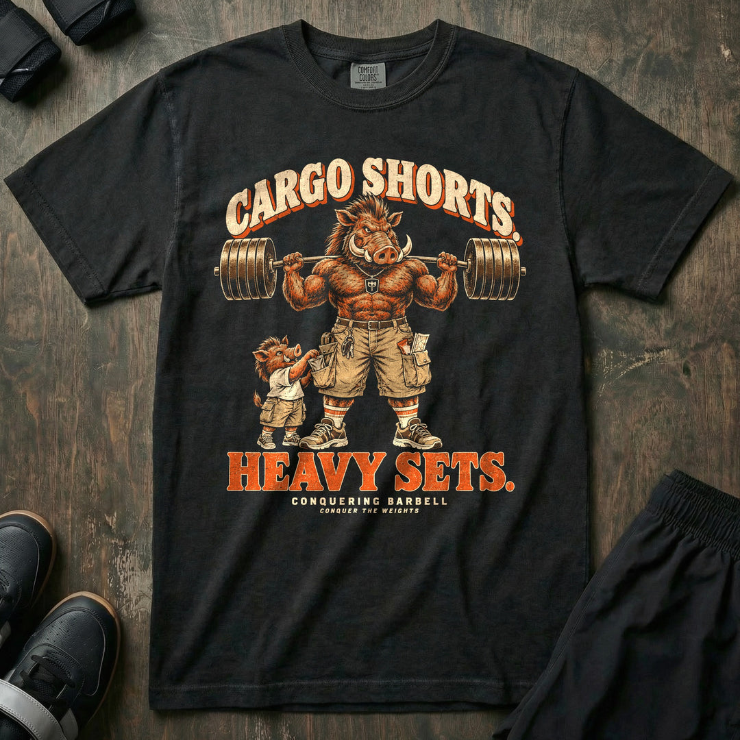Cargo Shorts. Heavy Sets - Relaxed Fit Tee front graphic in Black with a warthog dad in cargo shorts holding a loaded barbell on his back while a piglet in matching shorts reaches into his pocket - Conquering Barbell