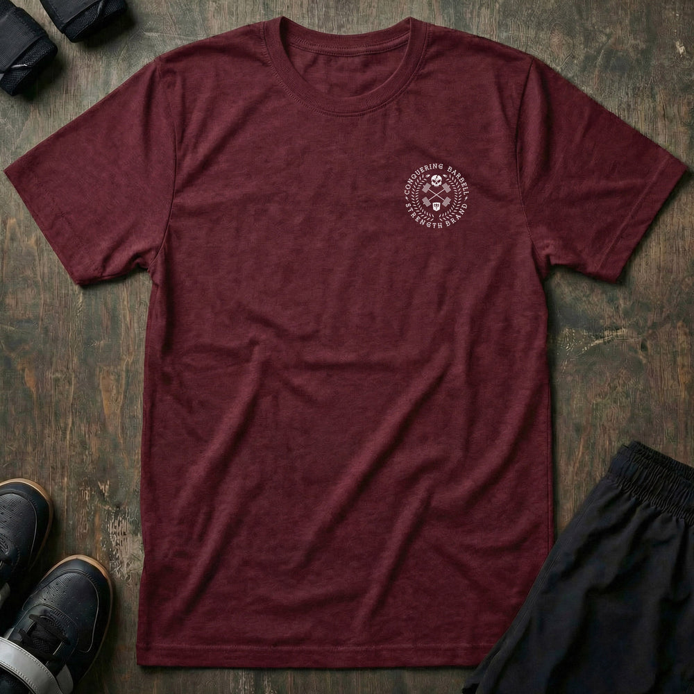 CB Badge Wreath tee in Maroon: a skull over crossed barbells inside a laurel wreath