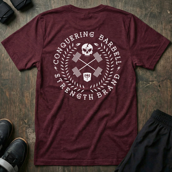 CB Badge Wreath tee in Maroon: a skull over crossed barbells inside a laurel wreath