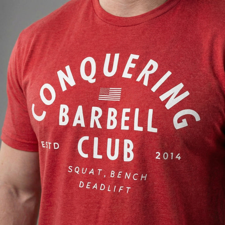 CB LIfting Club tee in Red: CONQUERING arched over an American flag