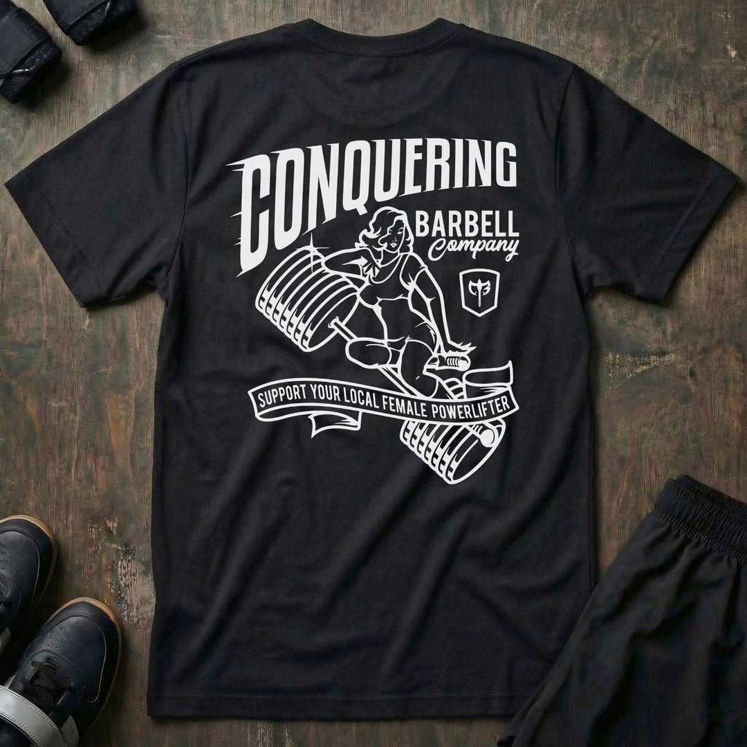 CB Pin-up tee in Black: a classic pin-up girl perched on a loaded barbell