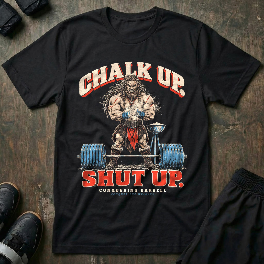 Chalk Up Shut Up - Tee front graphic in Black with a barbarian clapping chalk over a loaded barbell - Conquering Barbell