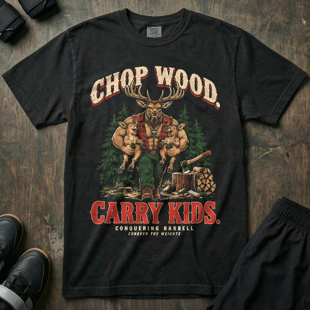 Chop Wood. Carry Kids - Relaxed Fit Tee front graphic in Black with a bull elk dad in a red flannel shirt carrying two laughing calves under his arms beside an axe in a stump and stacked firewood - Conquering Barbell