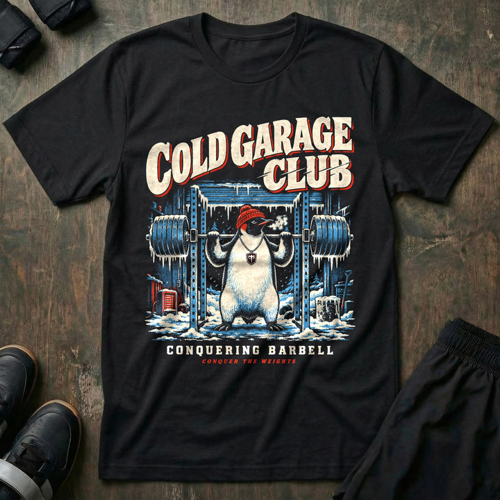 Cold Garage Club - Tee front graphic in Black with a penguin in a red beanie squatting in a frozen garage gym - Conquering Barbell