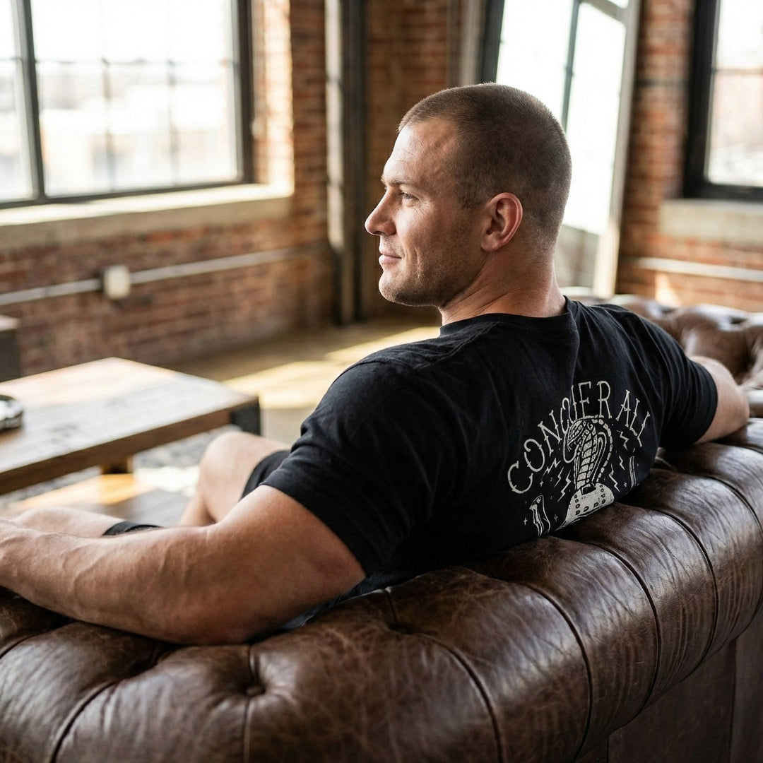 Conquer All Mask tee in Black: a distressed hockey mask wrapped in a coiling cobra