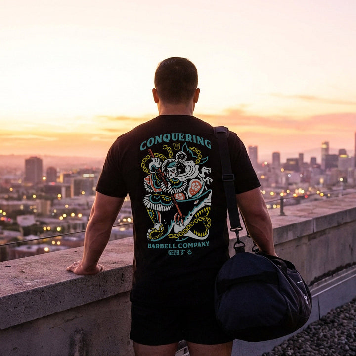 Conquer Bushido tee in Black: a tattoo-style samurai slaying a monstrous shark with chains and a katana in teal
