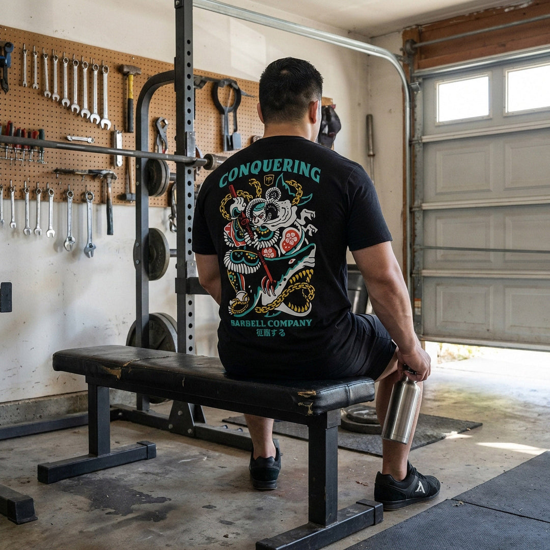 Conquer Bushido tee in Black: a tattoo-style samurai slaying a monstrous shark with chains and a katana in teal