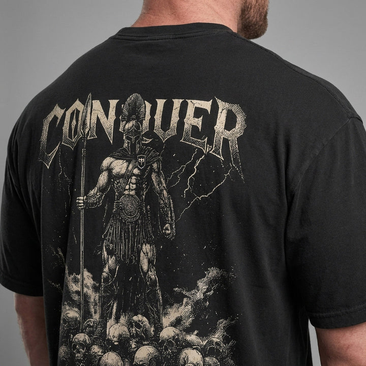Conquer Ares relaxed fit tee in Black: a Spartan warrior standing atop a mountain of skulls