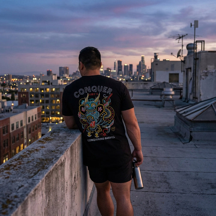 Conquer Gorilla tee in Black: an ornate tattoo-style gorilla wrapped in clouds and dragon scales in teal