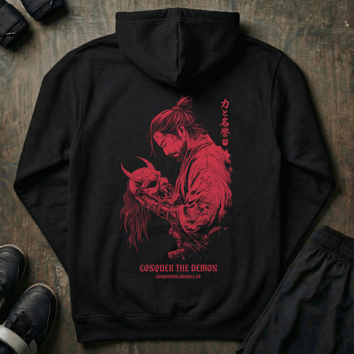 Conquer the Demon pullover hoodie in Black: a battle-worn samurai holding a defeated oni mask