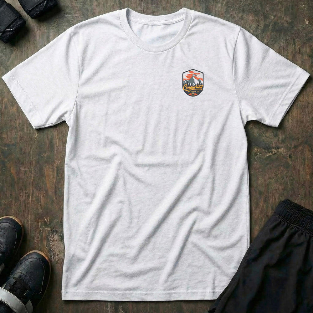 Conquer the Summit tee: a bold outdoor badge with snow-capped peaks above a pine tree line