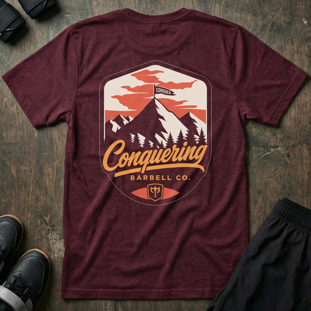 Conquer the Summit tee in Maroon: a bold outdoor badge with snow-capped peaks above a pine tree line
