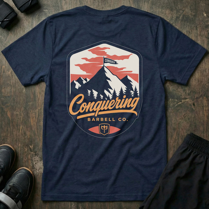 Conquer the Summit tee in Navy: a bold outdoor badge with snow-capped peaks above a pine tree line