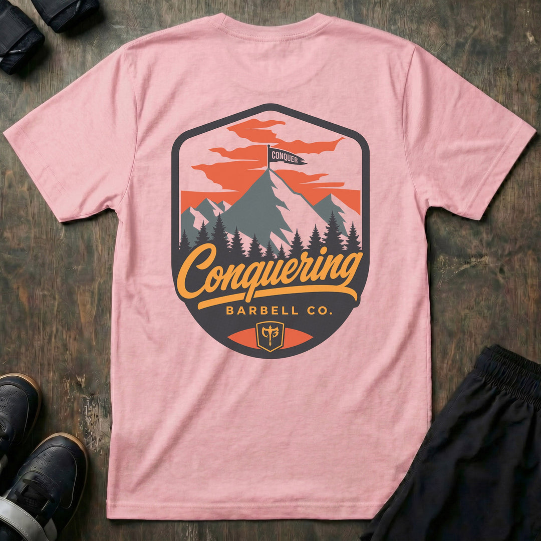 Conquer the Summit tee in Pink: a bold outdoor badge with snow-capped peaks above a pine tree line