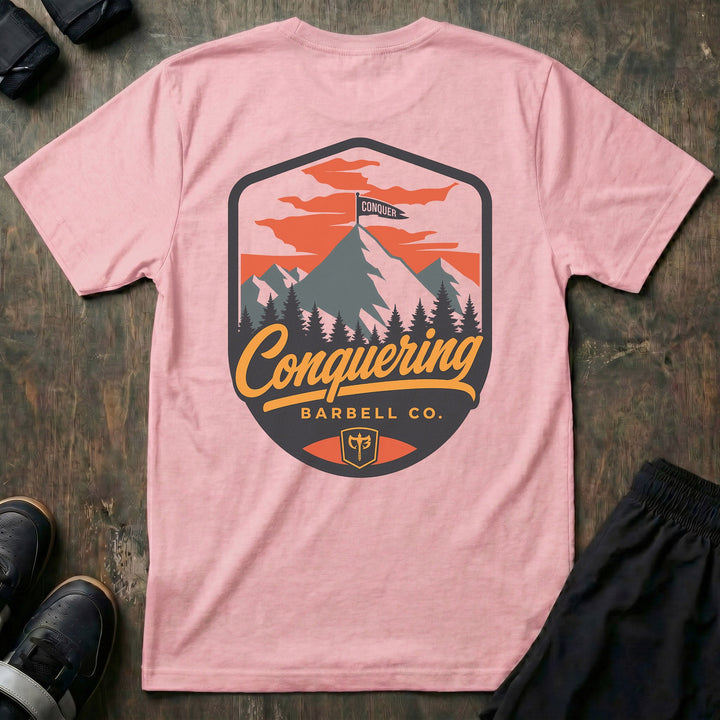 Conquer the Summit tee in Pink: a bold outdoor badge with snow-capped peaks above a pine tree line