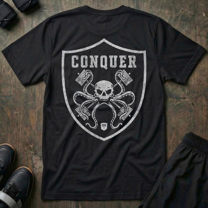 Conquer the Unknown tee in Black: a skull-headed octopus wrapping its tentacles around barbells inside a bold shield