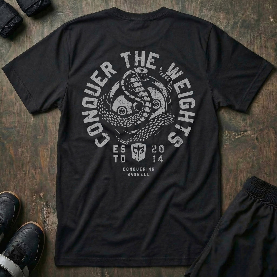 Conquer the Weights Cobra tee in Black: a coiled cobra rising over the CB shield inside a circular badge