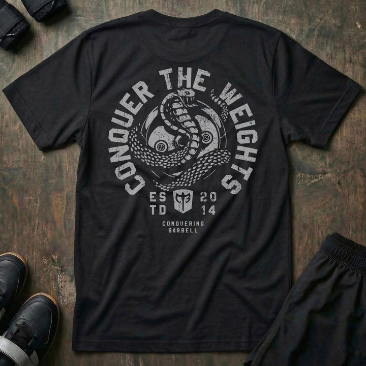 Conquer the Weights Cobra tee in Black: a coiled cobra rising over the CB shield inside a circular badge