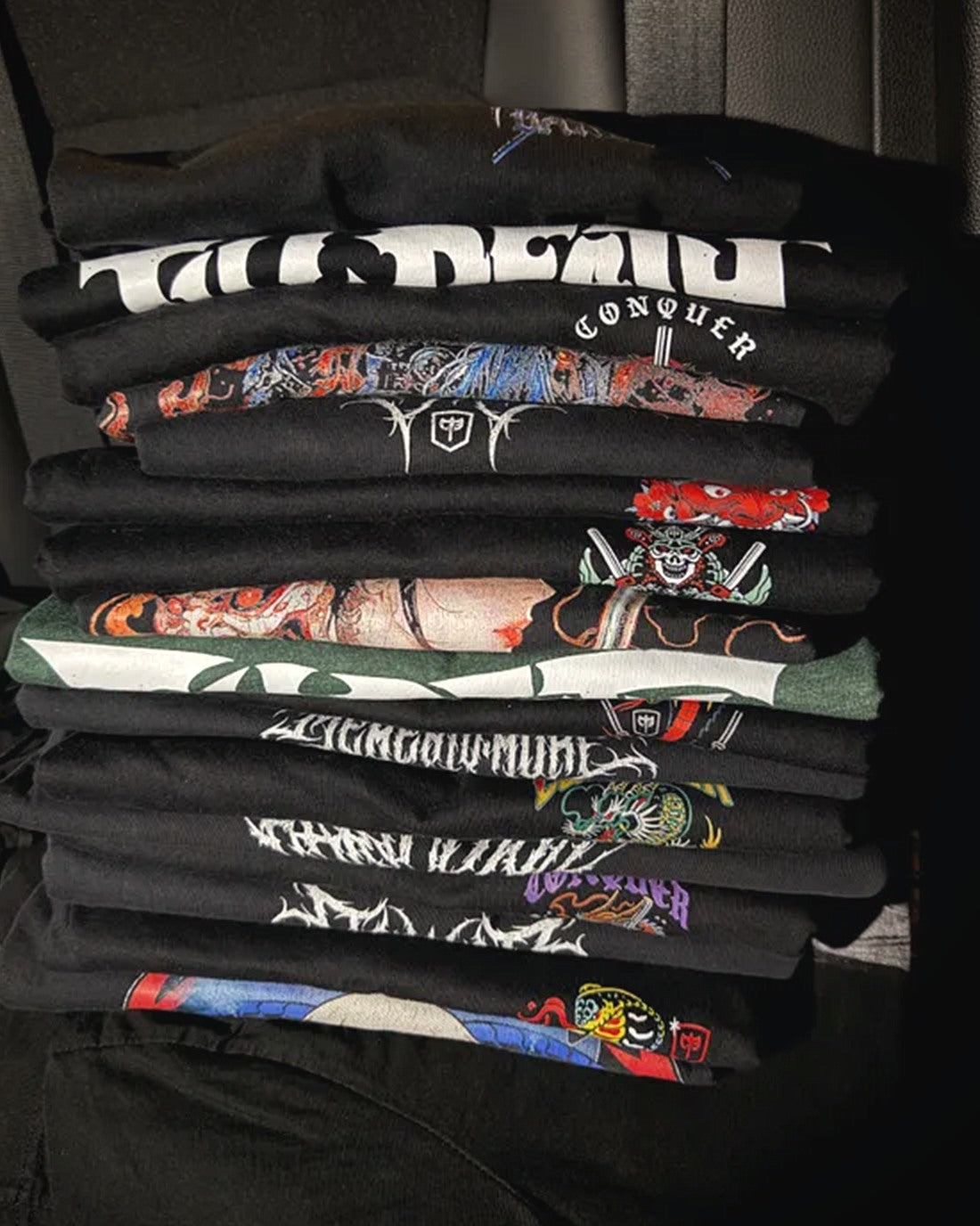 Carlos F.'s stack of Conquering Barbell shirts
