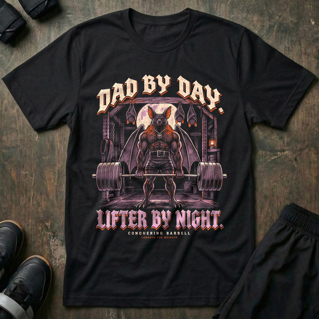 Dad by Day. Lifter by Night - Tee front graphic in Black with a bat dad with spread wings deadlifting a loaded barbell under a full moon with three baby bats sleeping upside down above him - Conquering Barbell