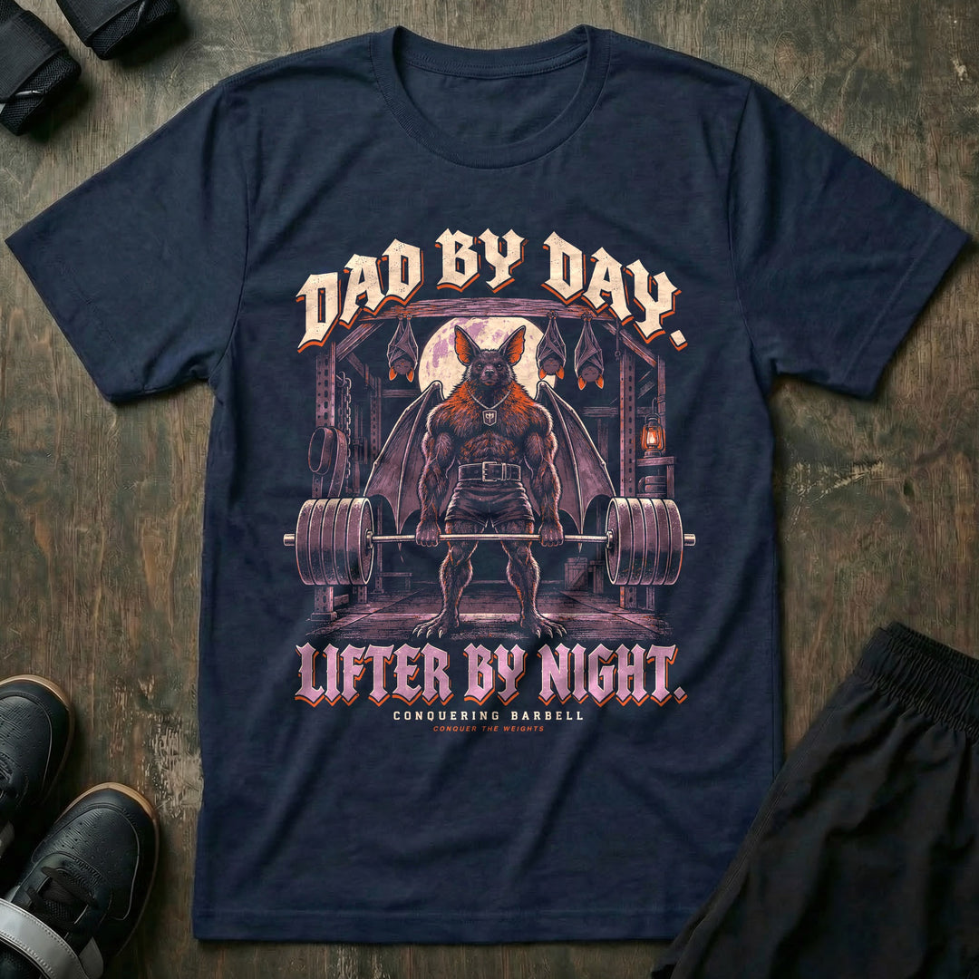 Dad by Day. Lifter by Night - Tee front graphic in Navy with a bat dad with spread wings deadlifting a loaded barbell under a full moon with three baby bats sleeping upside down above him - Conquering Barbell