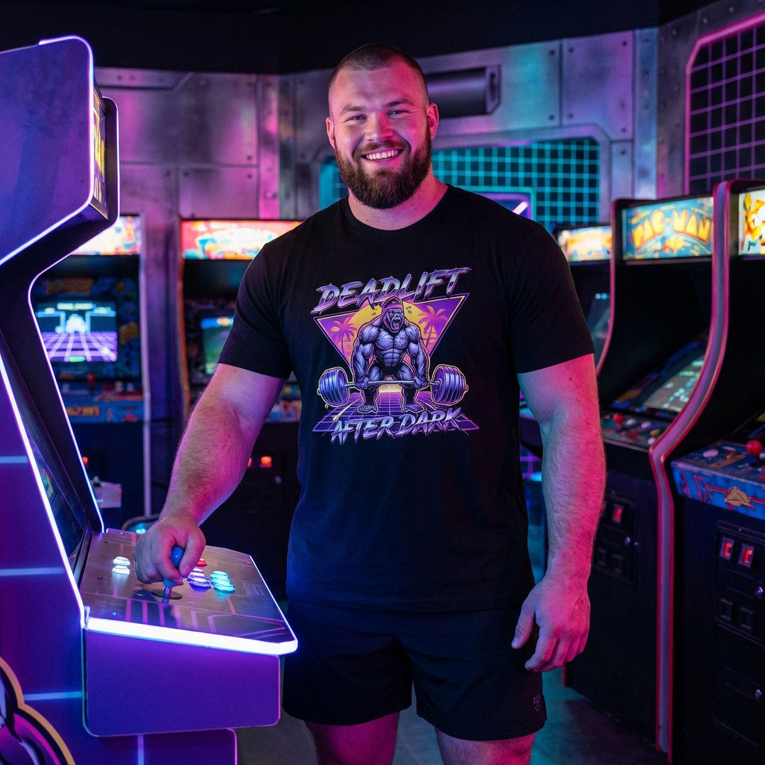 Deadlift After Dark tee in Black: a retro 80s-style gorilla pulling heavy in front of a neon triangle and palm trees