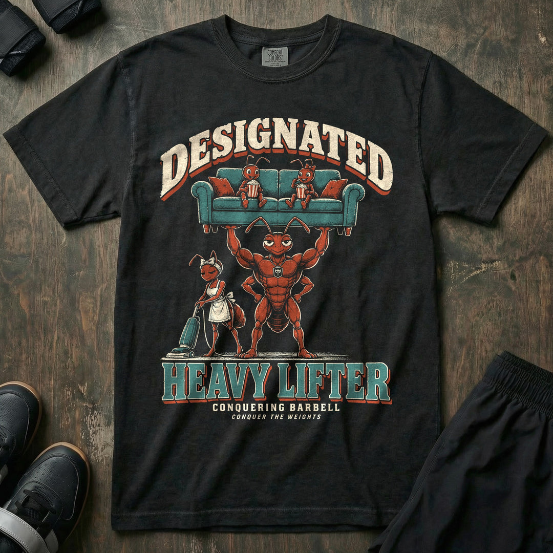Designated Heavy Lifter - Relaxed Fit Tee front graphic in Black with a muscular ant dad lifting a couch overhead with two young ants eating popcorn on it while another ant vacuums below - Conquering Barbell