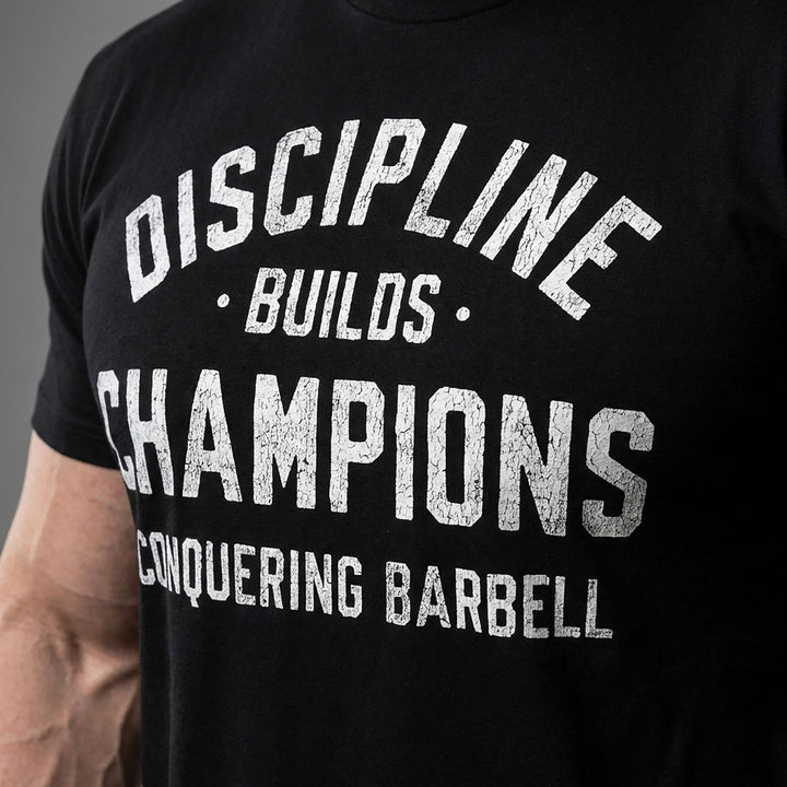 Discipline Builds Champions tee in Black: DISCIPLINE arched over BUILDS and CHAMPIONS in distressed collegiate letters