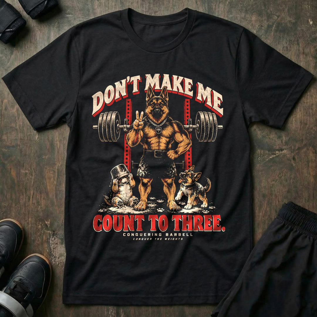 Don't Make Me Count to Three - Tee front graphic in Black with a German shepherd dad holding up two fingers in front of a squat rack while two puppies play in spilled chalk - Conquering Barbell
