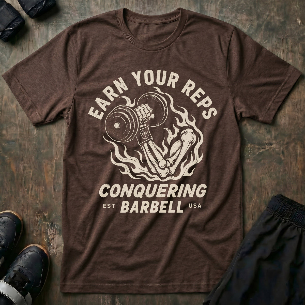 Earn Your Reps tee in Expresso: a skeletal hand rising from a ring of fire gripping a loaded dumbbell